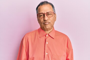 Middle age indian man wearing casual clothes and glasses depressed and worry for distress, crying angry and afraid. sad expression.