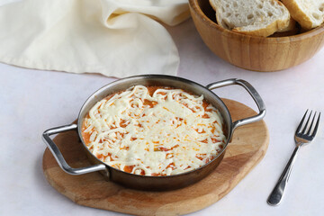 Tomato and peppered egg with melted cheese on wooden background