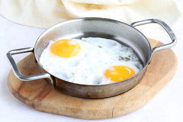 Fried eggs on wooden background