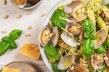 Salad made of pasta fusilli, seafood vongole, spinach, parmesan cheese and pine nut in a plate. Top view