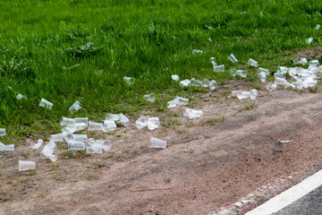 empty used plastic cups on the ground rubbish on the side of the road - environment pollution after marathon