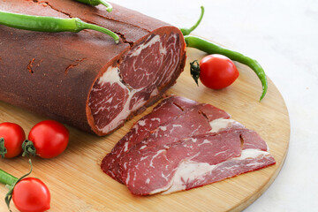 Turkish bacon , pastrami ( kayseri pastirma ) on wooden table