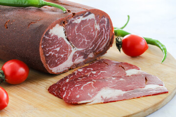 Turkish bacon , pastrami ( kayseri pastirma ) on wooden table