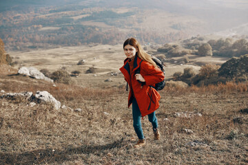 a traveler in a jacket jeans and boots climbs the mountains in nature landscape