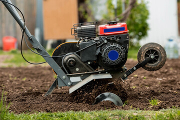 Banner. A male farmer plows the land with a cultivator. Agricultural machinery for tillage in the...