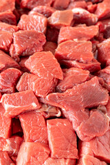 Meat cubes of beef on a white wooden background. Close up meat. Meat backround