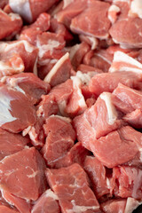 raw lamb cubed meat on white wooden background. Meat (food) backround. Close up lamb cube meat