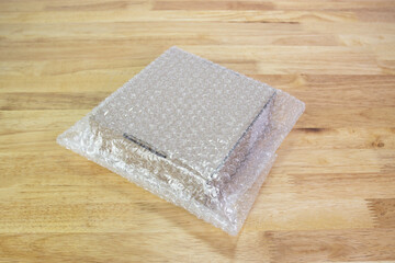 Bubbles covering the box by bubble wrap for protection product cracked on wood table