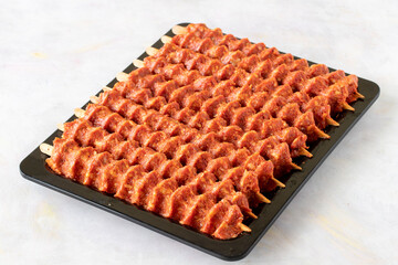 Spicy raw adana kebab on white wooden background.