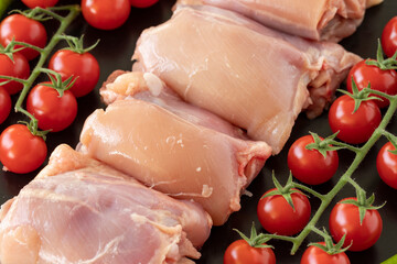 Raw boneless chicken thigh on a white wooden background. Chicken Meat background. Meat close-up