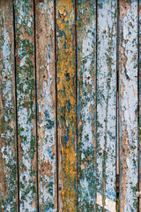 An old painted wooden fence near an old house.