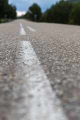 asphalt of a road with white lines in a straight line with a sunset skyline