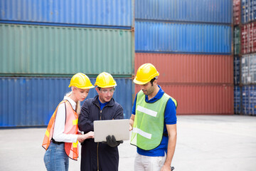 Group Foreman control Industrial Container Cargo freight ship. Foreman using laptop computer in the port of loading goods.