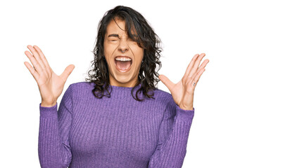 Young hispanic woman wearing casual clothes celebrating mad and crazy for success with arms raised...