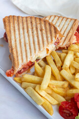 Tomato and cheese toast on a white wooden background. Local name ayvalık tostu