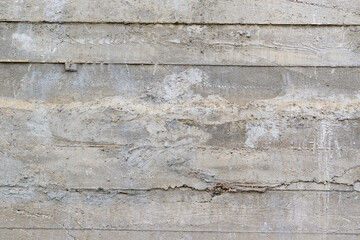 Fototapeta na wymiar Concrete wall surface with traces of formwork. Gray color, sagging.