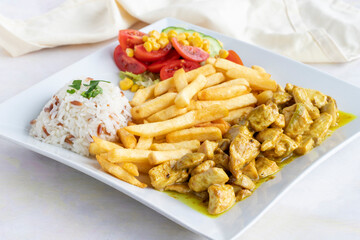 Chicken with curry sauce on a white wooden background. Local name köri soslu tavuk