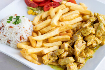 Chicken with curry sauce on a white wooden background. Local name köri soslu tavuk