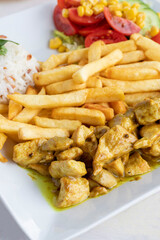 Chicken with curry sauce on a white wooden background. Local name köri soslu tavuk