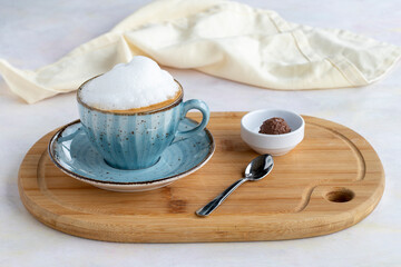 Foam cappuccino on a white wooden background