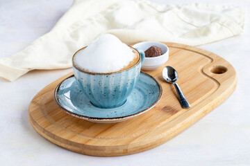 Foam cappuccino on a white wooden background