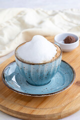 Foam cappuccino on a white wooden background