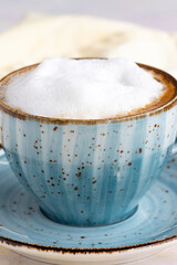 Foam cappuccino on a white wooden background