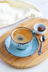 A cup of coffee on a white wooden background