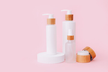 Cosmetic skin care products staying on the geometrical podiums. Product presentation on pink background.