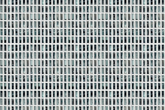 Facade of skyscraper with elongated rectangular windows, abstract colorless image, composite, concept for monotony