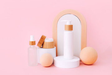 Cosmetic skin care products staying on the geometrical podiums. Product presentation on pink background.