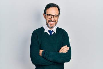 Middle age hispanic man wearing casual clothes and glasses happy face smiling with crossed arms...