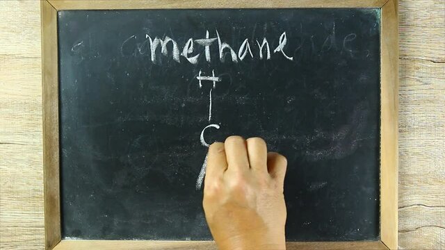 Man writing  methane  molecules on black board, in studio Chiangmai Thailand