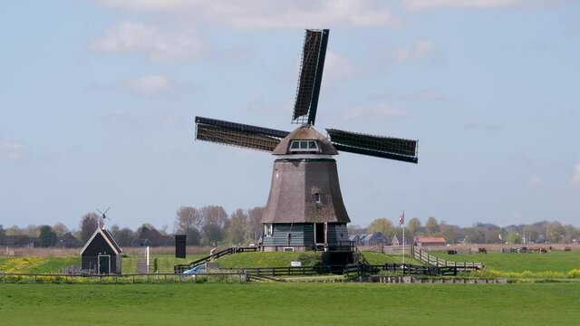 Historical windmill in Dutch landscape with beautiful clouds