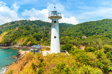 Fototapeta na wymiar Lighthouse on green coast. Sea lighthouse beacon on rock, Koh Lanta, Thailand