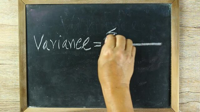 Man writing  Variance formula  on black board, in studio Chiangmai Thailand