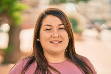 Young hispanic plus size woman smiling happy standing at the city.