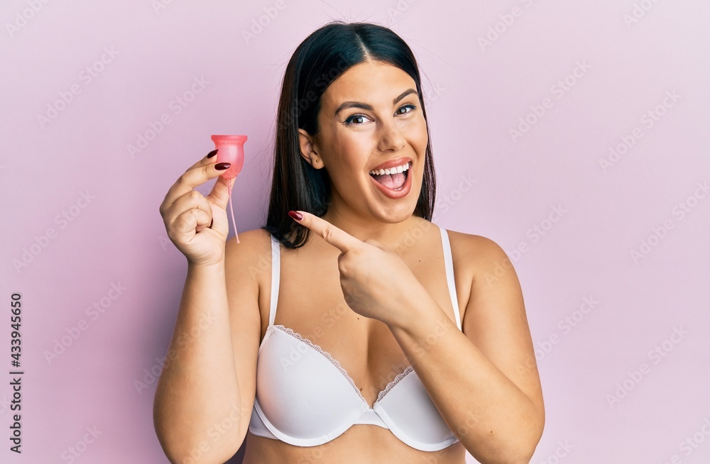 Sticker beautiful brunette woman holding menstrual cup wearing underwear looking positive and happy standing