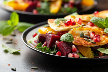 Fried Halloumi Cheese salad with beetroot, orange, pomegranate and pumpkin seeds, red onion, green vegetables. healthy food