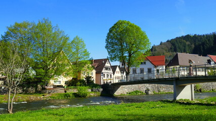 Fototapeta na wymiar romantisches Kinzigtal in Wolfach im Schwarzwald mit Fluss, Brücke und grüner Wiese unter blauem Himmel
