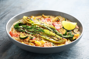 Asian style Pak choi, lemongrass, and ginger curried noodles served with lime wedges