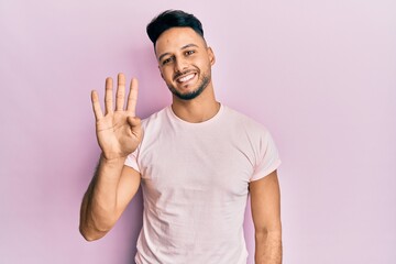 Fototapeta premium Young arab man wearing casual clothes showing and pointing up with fingers number four while smiling confident and happy.