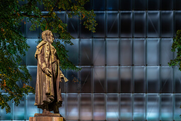 statue next to a glass building