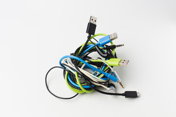 messy wire usb connector and earphone on white background