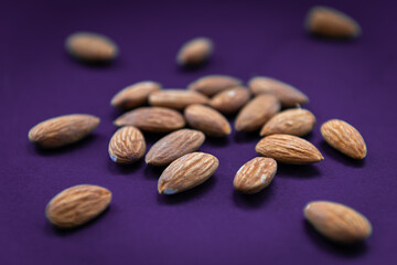 Delicious crunchy almonds isolated in a purple background.