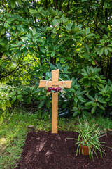 schönes Holzkreuz mit Blumendekoration