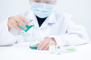 A little scientist is pouring blue liquid chemical in Erlenmeyer flask