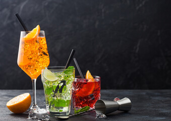 Glasses of spritz,mojito and negroni cocktails with ice cubes and lime and orange slices with mint...