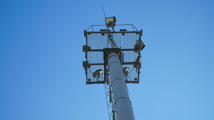 Obraz premium High lighting mast against the blue sky. View from below. Full height.