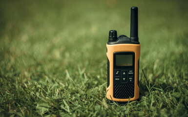 Radio walkie-talkie yellow for transmitting radio waves on green grass. Search